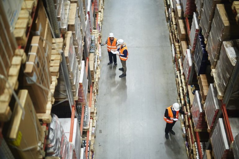 Above,View,Of,Warehouse,Workers,Group,In,Aisle,Between,Rows