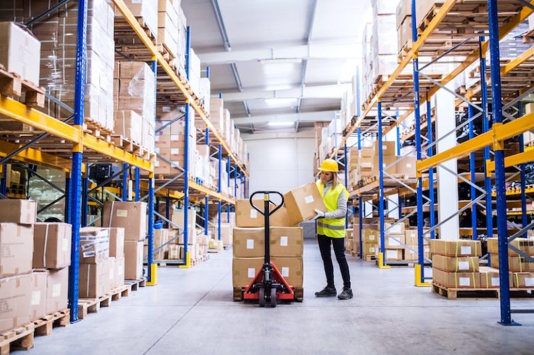 Woman in aisle of warehouse shelving
