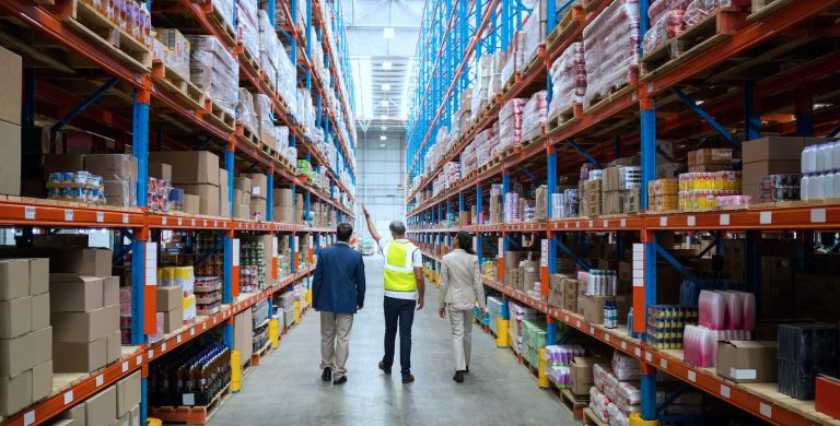 People inspecting a large warehouse aisle.