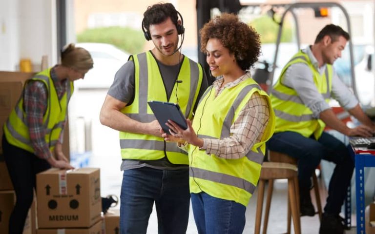 Warehouse workers collaborating on tasks.