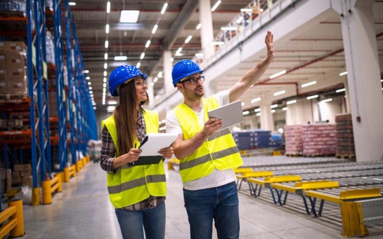 Workers discussing in warehouse environment.