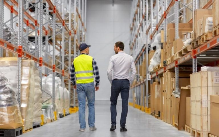 Two men walking in warehouse aisle