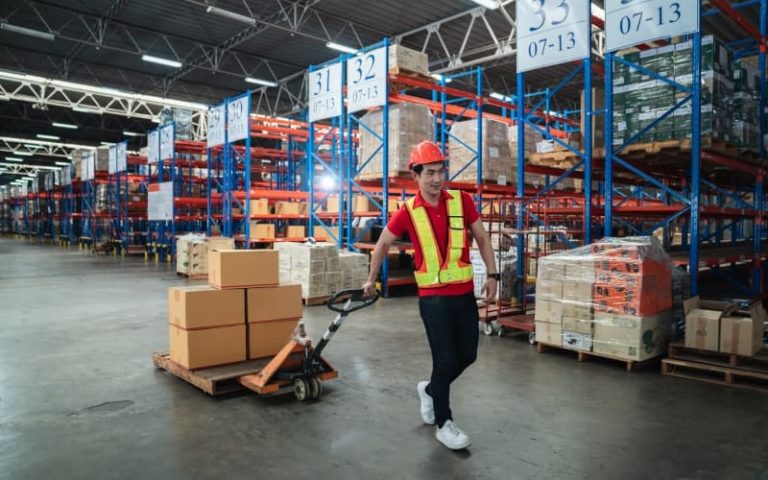 Warehouse worker moving boxes on pallet