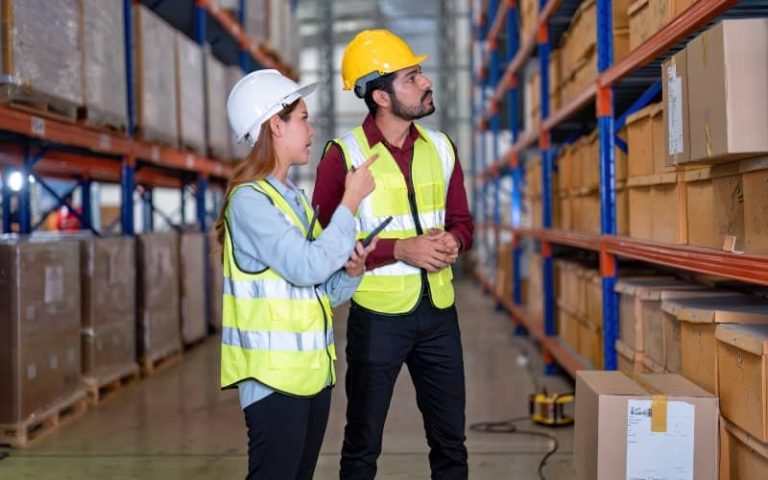 Warehouse workers discussing inventory management.