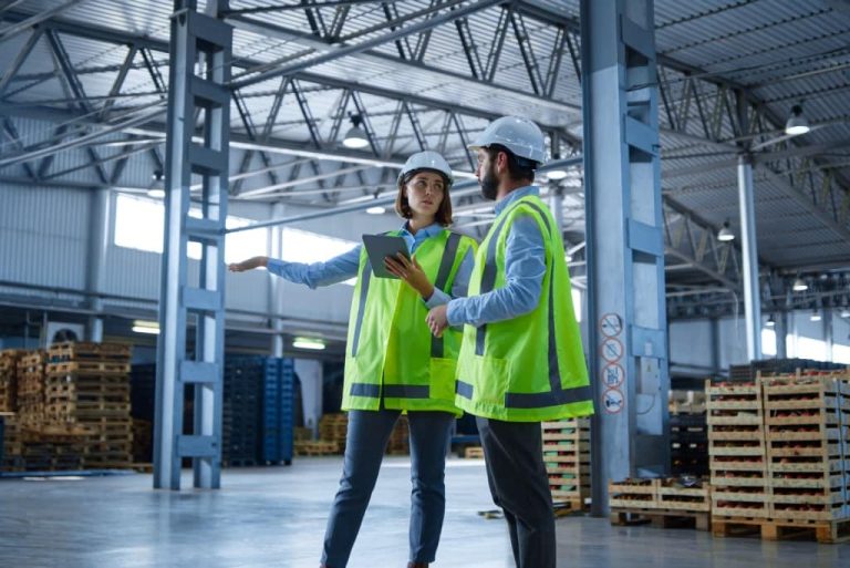 Two workers discussing in warehouse.
