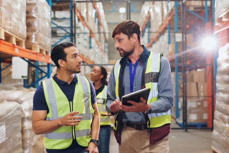 Warehouse workers discussing inventory management.