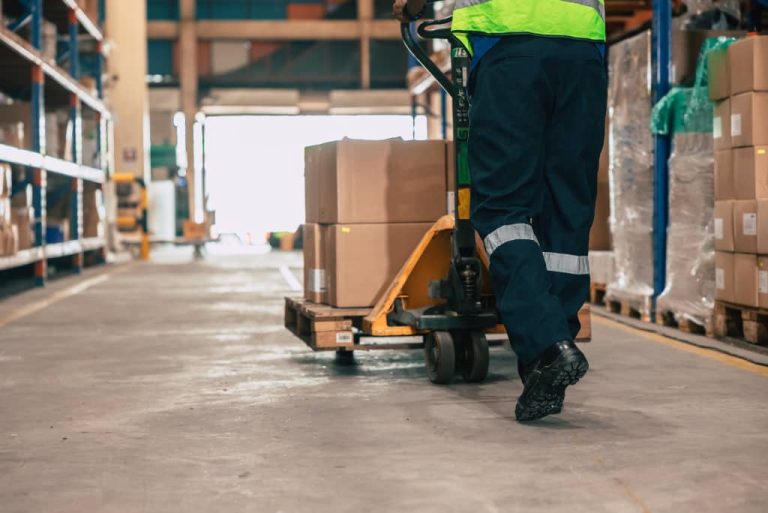 Worker moving boxes with pallet jack