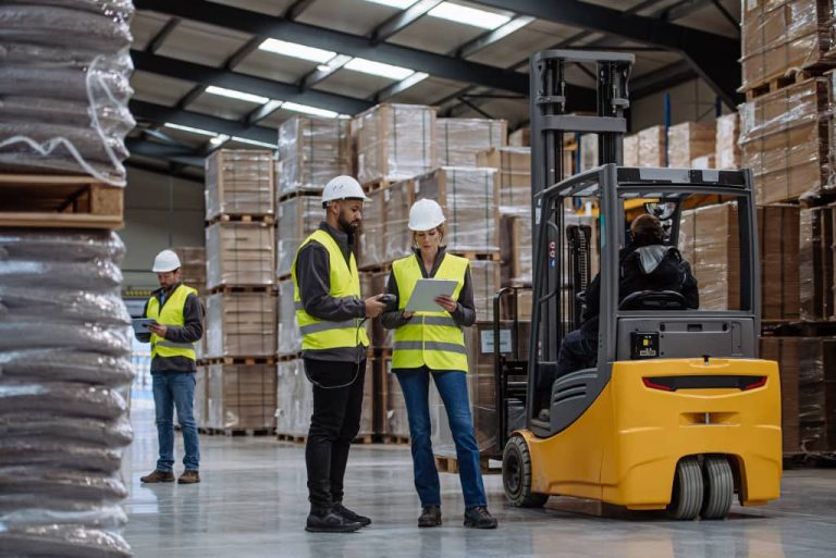 Warehouse workers coordinating with equipment.